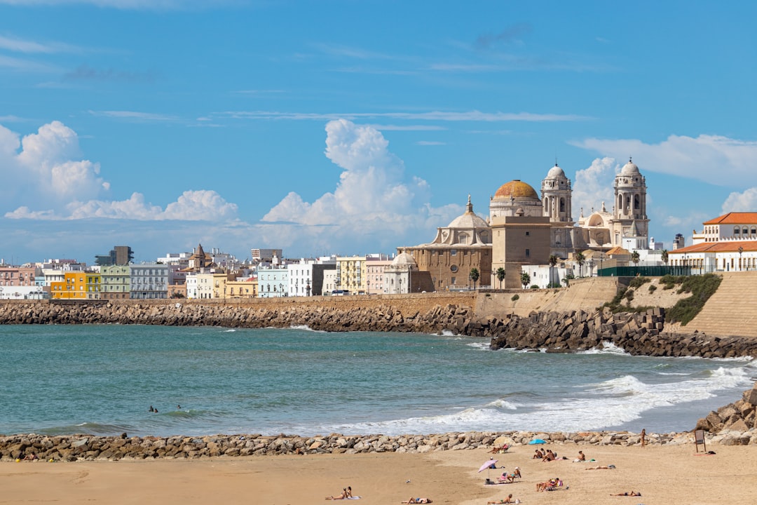 Photo by Jordi Vich Navarro a beach with buildings and a body of water in the background